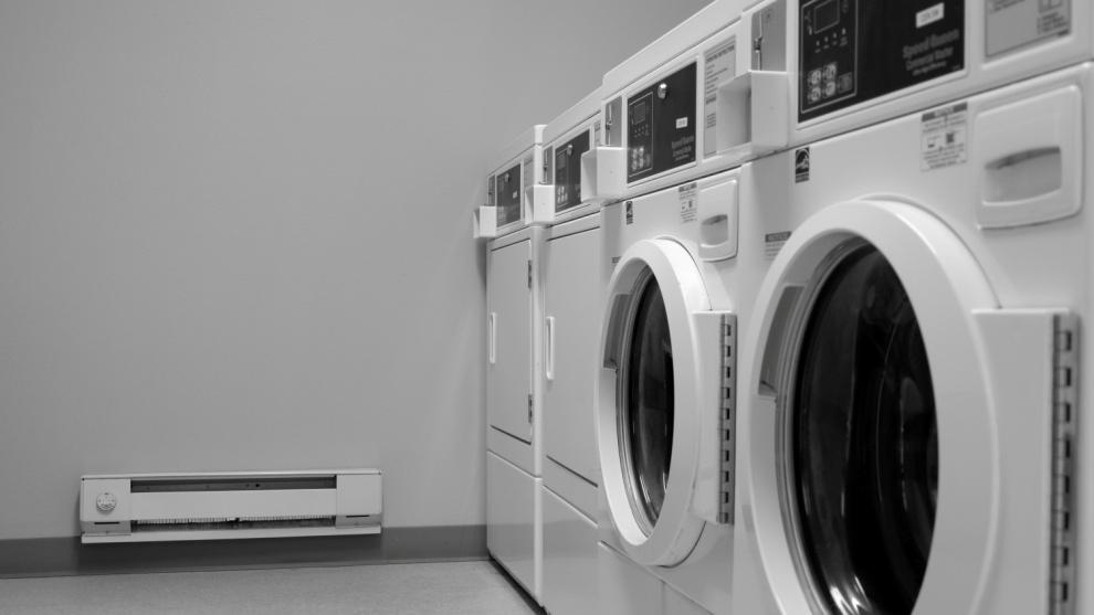 A row of modern energy-efficient washing machines in a laundromat