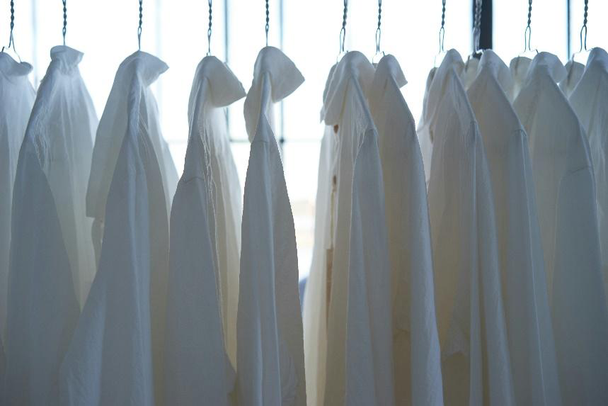 A crisp white dress shirt hanging on a rack