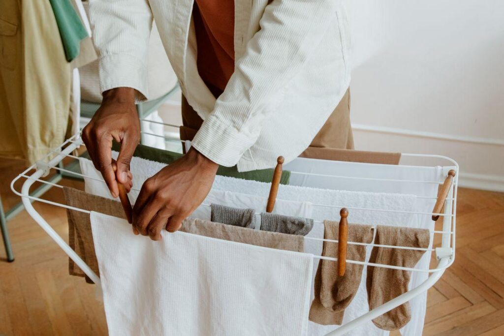 Person hanging clothes on a drying rack