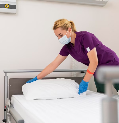Healthcare worker preparing clean patient bedding