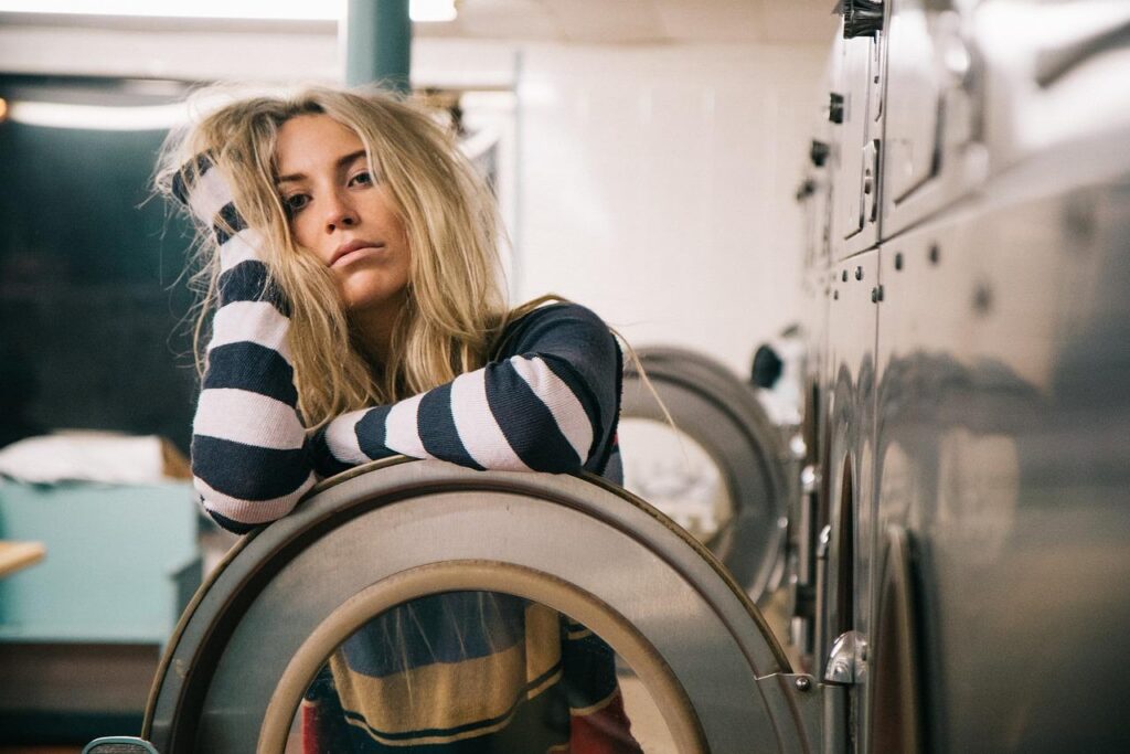 Person waiting beside the laundromat machines